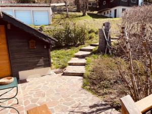 a stone walkway next to a house with a fence at LA GODILLE in La Clusaz
