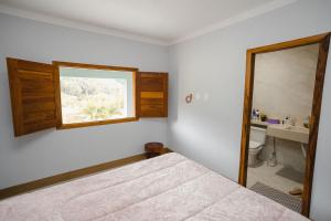 a bedroom with a bed and a window and a sink at Linda casa de campo com WiFi em Santa Teresa ES in Santa Teresa