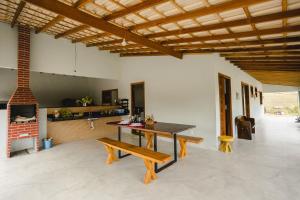 a dining room with a table and benches in a room at Linda casa de campo com WiFi em Santa Teresa ES in Santa Teresa