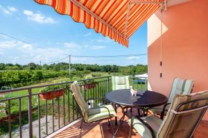 een patio met een tafel en stoelen op een balkon bij House Marko in Šumber