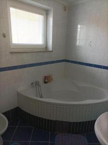 a bathroom with a tub and a window and a sink at RELAX in Kamnik +14 photos