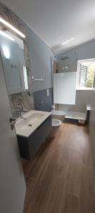 a bathroom with a sink and a large mirror at La perla della Conca d'Oro in Palermo