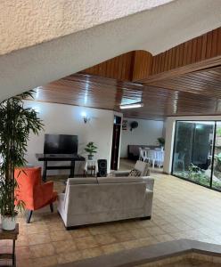 a living room with a couch and a tv at Hotel Palermo in Santa Cruz de la Sierra