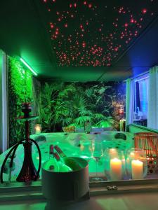 Cette chambre comprend une table avec des bougies et des lumières vertes. dans l'établissement Dolce vita Prémium, à Budapest