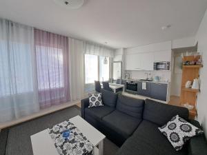 a living room with a couch and a kitchen at Makasiiniranta in Pori