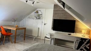 En TV eller et underholdningssystem på Mini hotel with home facilities in Hamilton West