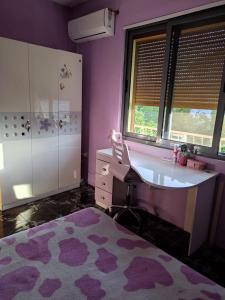 uma casa de banho roxa com um lavatório e uma banheira em Villa Green House em Shkodër
