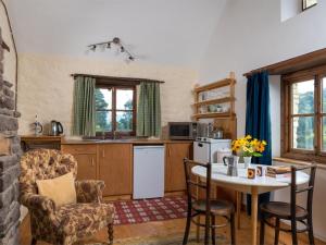 a kitchen with a table and two chairs and a table and a table and chairs at 1 bed in Llangynidr BN079 in Llangynidr