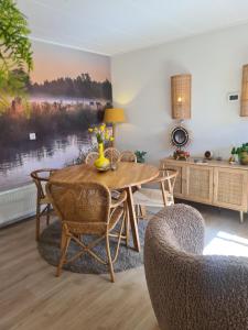a dining room with a wooden table and chairs at Een Nije Dei in Arum