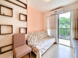 a room with a couch and a chair and a window at Apt 402 · Apt 2 qts,1,3 km do Rio Centro, Junesse , conf., s in Rio de Janeiro