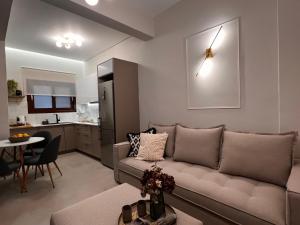 a living room with a couch and a kitchen at Oikiaegina 1 in Aegina Town