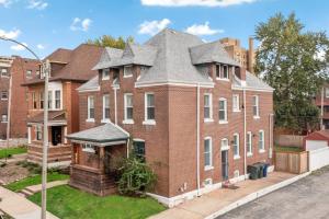 una gran casa de ladrillo rojo con techo gris en Luxury Living: Grand 7BR/5BA near Everything, en Tower Grove