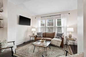 una sala de estar con un sofá y una mesa en Luxury Living: Grand 7BR/5BA near Everything, en Tower Grove