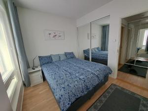 a bedroom with a blue bed and a mirror at Makasiiniranta in Pori