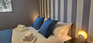 een slaapkamer met een bed met blauwe en witte kussens bij Rahal - Luxury house with pool - A perferfect getaway in Catania