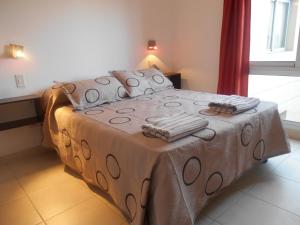 a bedroom with a bed with a blanket and a window at Departamento Dean Funes in Salta