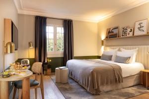 a bedroom with a bed and a table and a desk at Briqueterie Champagne, A Beauvallon Hotel & Spa in Vinay +99 photos