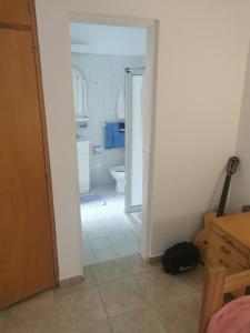 um quarto com uma casa de banho com um WC e uma guitarra em Cuarto privado separado de la casa principal y con entrada independiente em Corrientes