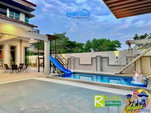 ein Haus mit einem Pool und einer Rutsche in der Unterkunft Villa 20Pax4B3B PrivatePool /Karaok/Pooltable/BBQ in Malakka