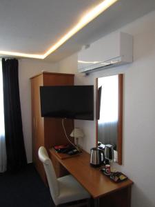 a hotel room with a desk with a television on it at Altstadthotel-Rheine in Rheine