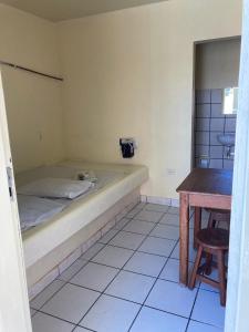 a small room with a bed and a table at Pousada Caliente in Maceió