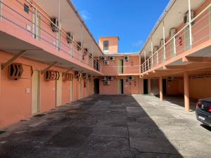 an empty alley between two buildings with a car parked at Pousada Caliente in Maceió