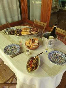 uma mesa com pratos de comida e uma garrafa de vinho em La Casetta del Melograno em Mondello