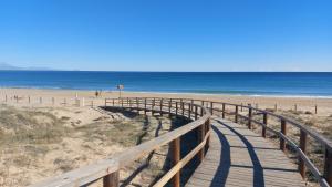a boardwalk to the beach with the ocean in the background at Arenales Sea View Apartment in Arenales del Sol