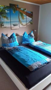 two beds in a room with blue pillows on them at Landhaus Westrich in Walldürn