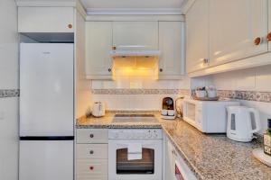 a kitchen with white cabinets and white appliances at Casita Bonita - with private garden near beach in Jávea in Jávea