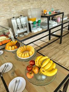 una mesa con plátanos y manzanas y otros alimentos en ella en Hotel Pigalle, próximo a Expo São Paulo, en São Paulo