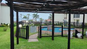 a black gate with a pool in the background at Topanga 17 in Uvongo Beach