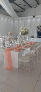 Cette chambre comprend une grande table avec des chaises et des verres à vin. dans l'établissement LalaManzi River Lodge, à Vanderbijlpark