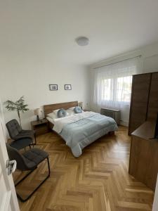 um quarto com uma cama grande e uma cadeira em Attila Vendégház em Balatonboglár