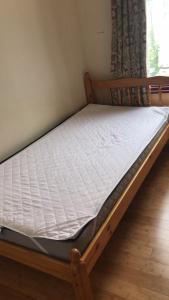 a bed in a room with a white mattress at London Homestay with big double room in London