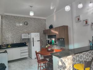a kitchen with a table and a white refrigerator at Pousada Bem-te-vi in Aracaju