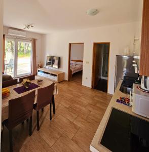 Il comprend une cuisine et un salon avec une table et des chaises. dans l'établissement Apartment Lili, à Biograd na Moru