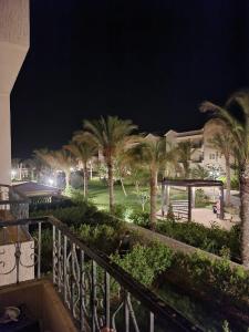 a balcony of a building with palm trees at night at Tavira Resort in Ras Sedr