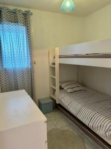 een slaapkamer met 2 stapelbedden en een raam bij Appartement classé, vue mer, clim, wifi, parking in La Grande-Motte
