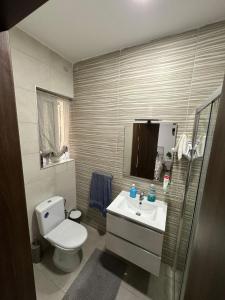 a bathroom with a white toilet and a sink at Private Room in Beatifull Aparment in Birkirkara