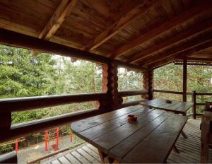 una mesa de madera en una cabaña con 2 ventanas en Котедж 4Сезони en Slavske