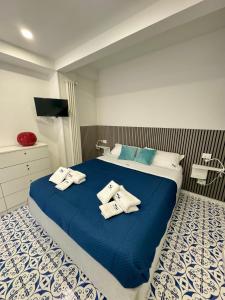 una camera da letto con un letto blu e asciugamani di Panoramic Flat Amalfi Coast - Sea View 2 a Vietri