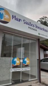 d'un panneau indiquant la surface de l'homme et la concession de meubles dans l'établissement Pousada Mar Suites Toninhas, à Ubatuba
