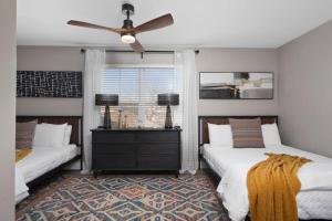 a bedroom with two beds and a ceiling fan at Modern Escape: 5BR/2.5BA Near St. Louis Must-Sees in Saint Louis