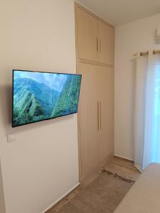 a flat screen tv on a wall in a bedroom at Seafront Haven in Kalymnos