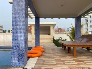 a patio with a table and a swimming pool at Saikat Saranya Resort, Mandarmoni Beach in Mandarmoni
