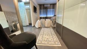 een kamer met een spiegel, een stoel en een bed bij Atalaya Apartment by Hello Homes Sitges in Sitges