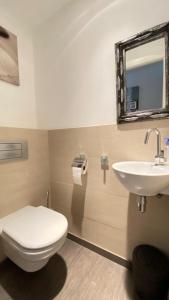een badkamer met een toilet, een wastafel en een spiegel bij Atalaya Apartment by Hello Homes Sitges in Sitges