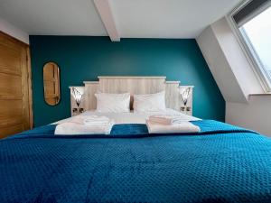 um quarto com uma cama grande e uma parede azul em The Bath Rooms em Morecambe