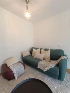 een woonkamer met een groene bank met kussens bij Modern, private spacious & fully equipped for 2-6 people Near forest, with kitchen, washer, pets friendly in Floda